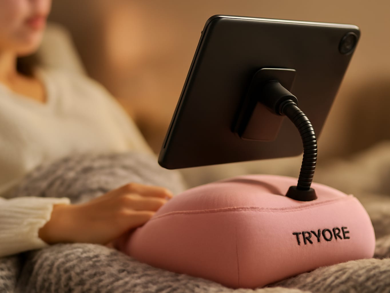 The Most Comfortable Way to Use Your Tablet in Bed (Tryone Review): A person lying in bed using the pale pink Tryone tab